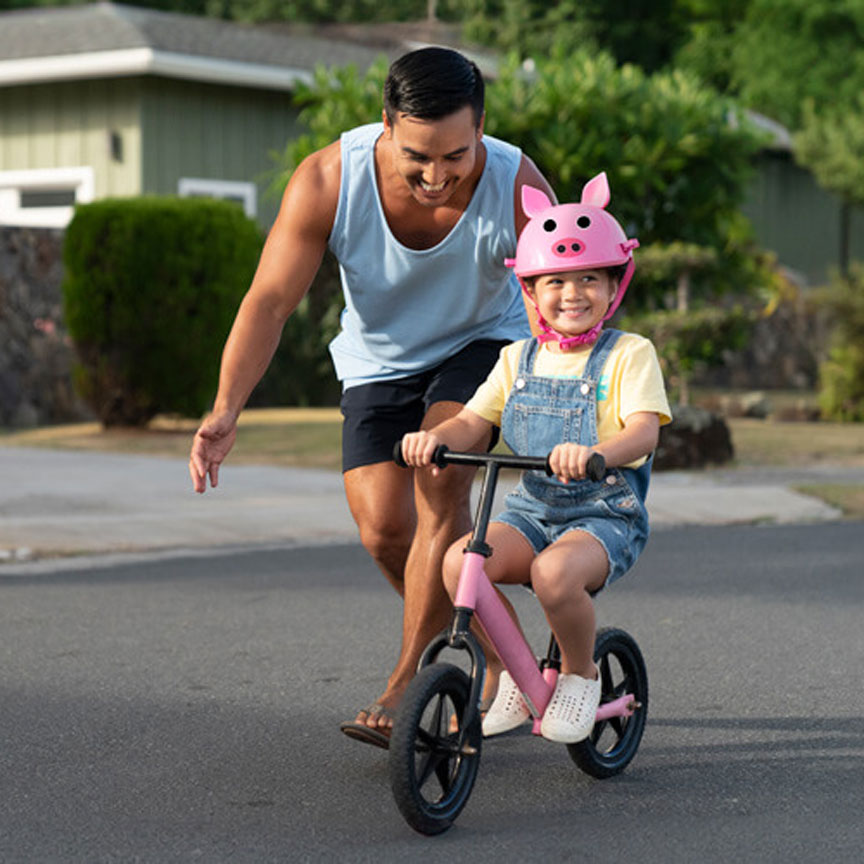 dad chasing daughter riding training bicycle